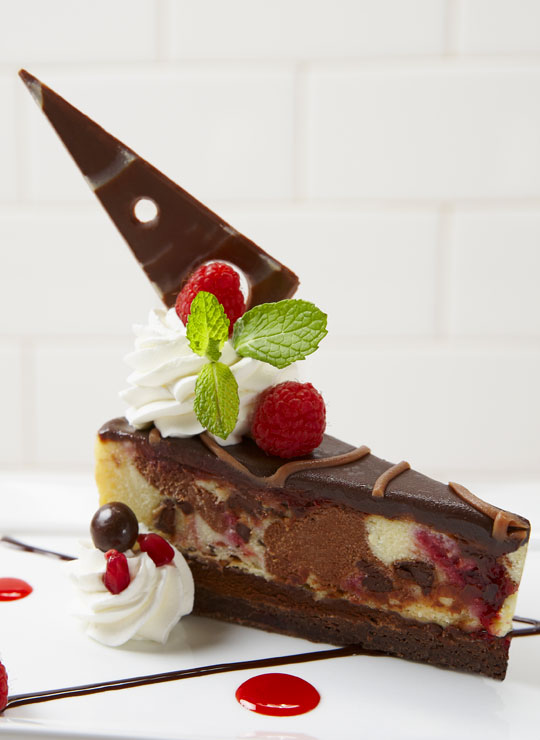 A slice of Chocolate Raspberry Cheesecake made with Ghirardelli®
