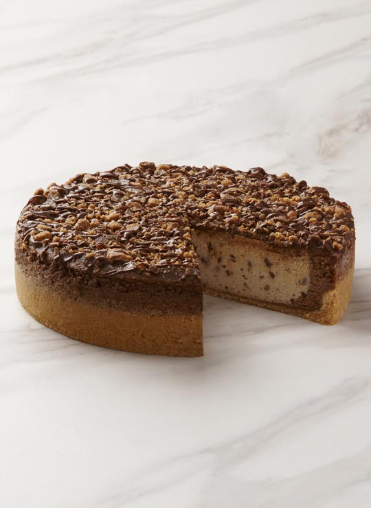 A slice of Reese's Peanut Butter Cheesecake, garnished with a mini Reese's Peanut Butter Cup